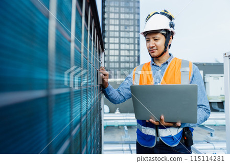 Man engineer holding laptop working at rooftop building construction. 115114281
