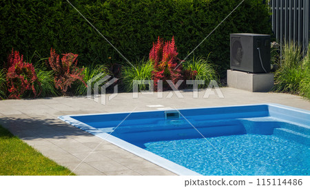 Heat pump unit by a pool with decorative plants around. 115114486