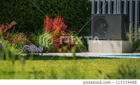 Heat pump unit next to a pool with surrounding ornamental plants. 115114488