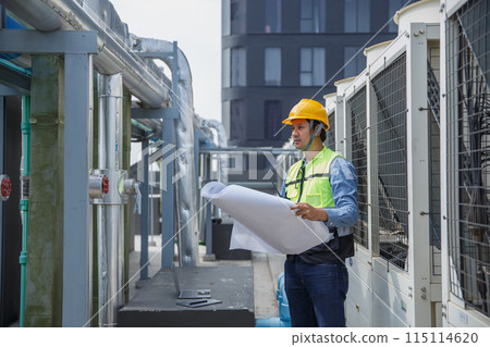 Male operator worker reading blueprint checking drawing plan cooling air piping HVAC system Male operator worker reading blueprint checking drawing plan cooling air piping HVAC system 115114620