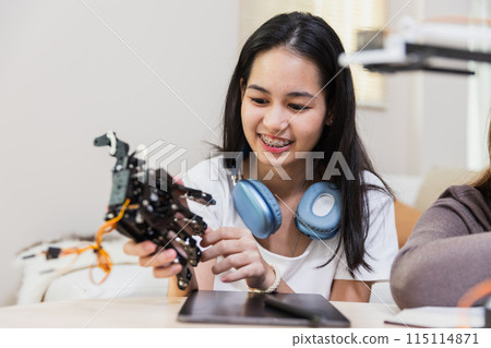 Happy two girl teen smile with braces students education stem hand robot model study Happy two girl teen smile with braces students education stem hand robot model study 115114871