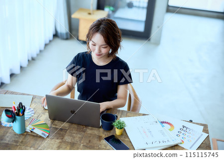 A female designer working at a computer at home A female designer working at a computer at home 115115745