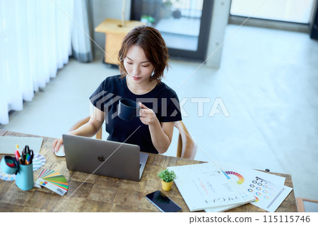 一位女設計師在家用電腦工作 115115746