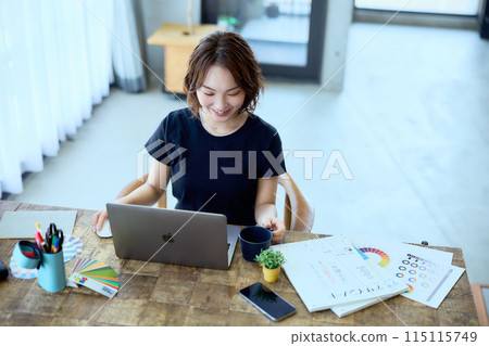 一位女設計師在家用電腦工作 115115749