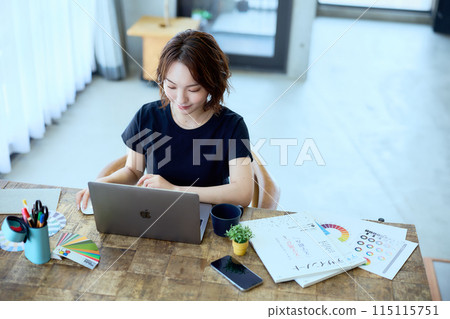 一位女設計師在家用電腦工作 115115751