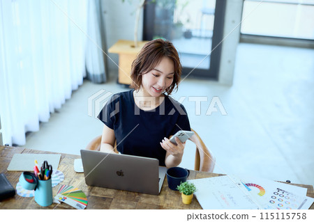 一位女設計師在家用電腦工作 一位女設計師在家用電腦工作 115115758