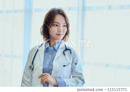 Female doctor standing by the window Female doctor standing by the window 115115771