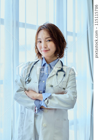 Female doctor standing by the window Female doctor standing by the window 115115786