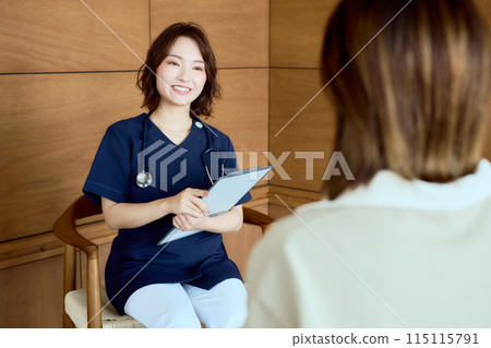A female doctor interviewing a patient in the waiting room A female doctor interviewing a patient in the waiting room 115115791