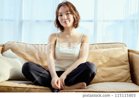 A woman sitting on a sofa and relaxing 115115803