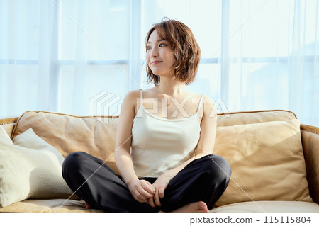 A woman sitting on a sofa and relaxing 115115804
