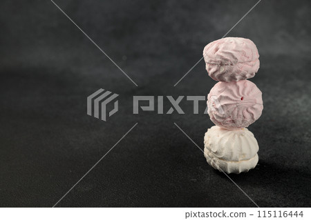 white and pink marshmallows on a black background 115116444
