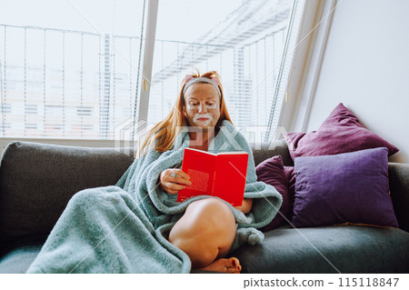 portrait middle-aged woman with cosmetic mask on face on sofa at home portrait middle-aged woman with cosmetic mask on face on sofa at home 115118847
