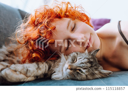 portrait red-haired teenage girl with gray fluffy cat 115118857