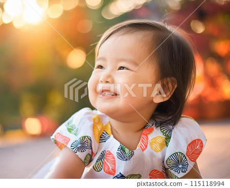 Smiling baby playing outdoors 115118994