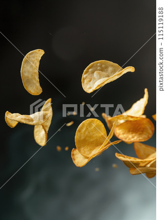 High quality photo of crispy potato chips caught in mid-flight against a dark backdrop, conveying the texture and crunchiness of the snack, ideal for advertising and culinary presentations 115119188