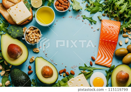 Keto diet background with copy space for text. Nutritious Ingredients for Healthy Eating with Salmon, Avocado, Nuts, and Greens on a blue background. 115119799