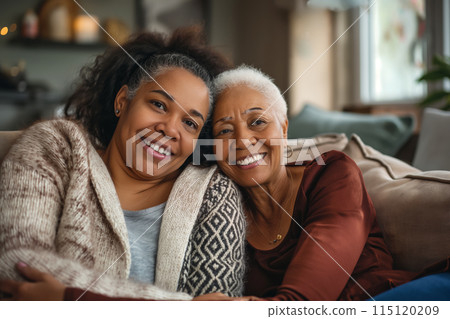 Family photo of an elderly mother and her adult daughter on the sofa in cozy living room, women looking at the camera, charming photo captures the essence of family connections, Mother's Day portrait Family photo of an elderly mother and her adult daughter on the sofa in cozy living room, women looking at the camera, charming photo captures the essence of family connections, Mother's Day portrait 115120209