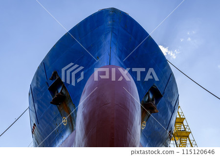 Cargo vessel in dry dock on ship repairing yard. Bulbous bow. 115120646