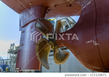 Cargo vessel in dry dock on ship repairing yard. Variable pitch propeller and rudder. Cargo vessel in dry dock on ship repairing yard. Variable pitch propeller and rudder. 115120671