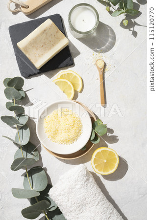 Flat lay organic yellow sea salt with lemon, soap, towel, brush  and eucalyptus branch 115120770