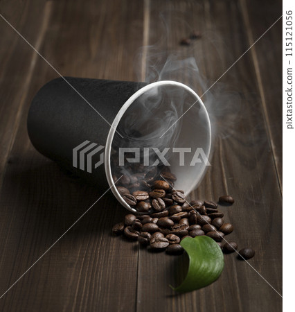 fresh aromatic coffee beans scattered on a dark wooden background from a plastic disposable cup 115121056