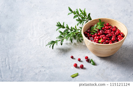 juicy forest lingonberry  in a wooden bowl on white table. Concept healthy food. Close up  115121124