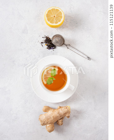 Concept cup of tea with lemon, mint and ginger on a white textured background. Top view Concept cup of tea with lemon, mint and ginger on a white textured background. Top view 115121139