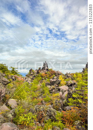 Autumn leaves on rocks and the autumn sky [Onioshidashi Park] 115122883