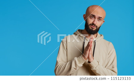 Middle eastern man praying to Allah for forgiveness, being religious and having belief in God. Arab person posing with hands in a prayer to worship Jesus, spiritual emotions. Camera 2. Middle eastern man praying to Allah for forgiveness, being religious and having belief in God. Arab person posing with hands in a prayer to worship Jesus, spiritual emotions. Camera 2. 115123133