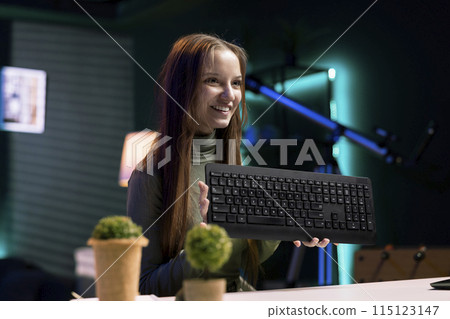 Cheerful content creator analyzing mechanical keyboard received from sponsor, doing honest review for online streaming channel. Internet show host reviewing computer peripherals brand Cheerful content creator analyzing mechanical keyboard received from sponsor, doing honest review for online streaming channel. Internet show host reviewing computer peripherals brand 115123147