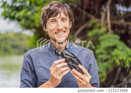 Man eating Vietnamese Pork Banh Mi Sandwich in a black baguette Man eating Vietnamese Pork Banh Mi Sandwich in a black baguette 115123996