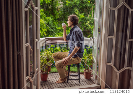 man stands on a heritage-style balcony enjoying his morning coffee. A man in a hotel in Europe or Asia as tourism recovers from a pandemic. Tourism has recovered thanks to vaccinations. Woman 115124015