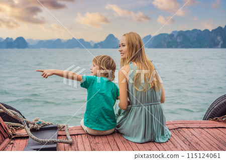Mom and son travelers is traveling by boat in Halong Bay. Vietnam. Travel to Asia, happiness emotion, summer holiday concept. Traveling with children concept. After COVID 19. Picturesque sea landscape Mom and son travelers is traveling by boat in Halong Bay. Vietnam. Travel to Asia, happiness emotion, summer holiday concept. Traveling with children concept. After COVID 19. Picturesque sea landscape 115124061