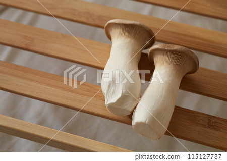 Two king oyster mushrooms on a wooden board 115127787