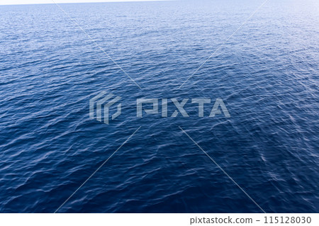 sun glare on the surface of blue sea water 115128030