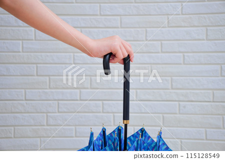 Child's hand holding an umbrella Child's hand holding an umbrella 115128549