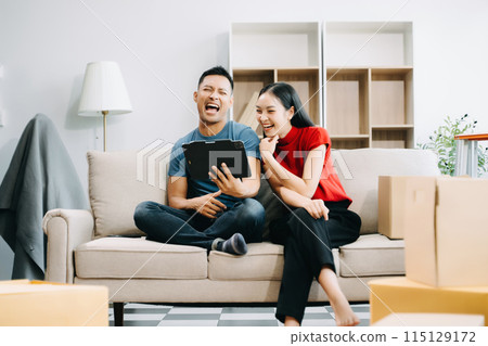 Happy asian young attractive couple man and woman with big boxes moving into a new house, new apartment for couple the new home, Moving house. . Happy asian young attractive couple man and woman with big boxes moving into a new house, new apartment for couple the new home, Moving house. . 115129172