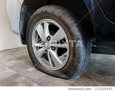 Closeup car flat tire on the road. Closeup car flat tire on the road. 115129310