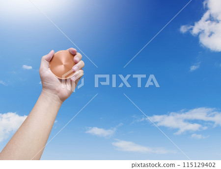 holding a bronze coin on the sky background Winner and success concept holding a bronze coin on the sky background Winner and success concept 115129402