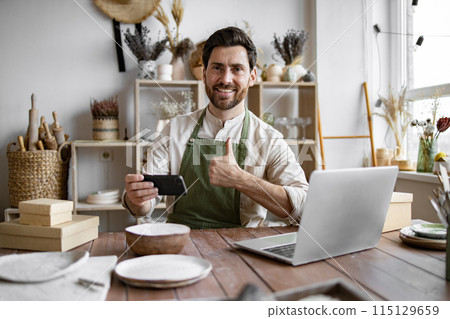 Caucasian male updates web page and social media portfolio. 115129659