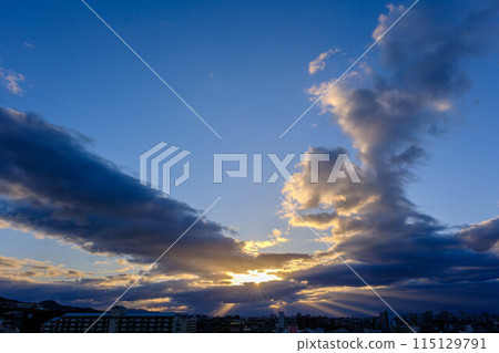 城市的黎明。太陽的光芒從雲層的縫隙中漏進來，天使的天梯降臨。 115129791