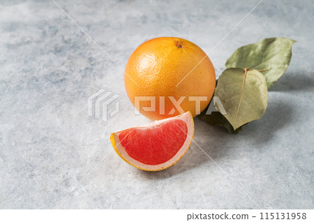 Juicy red grapefruit with slice and green leaf  on a blue background. Concept healthy and diet food. 115131958