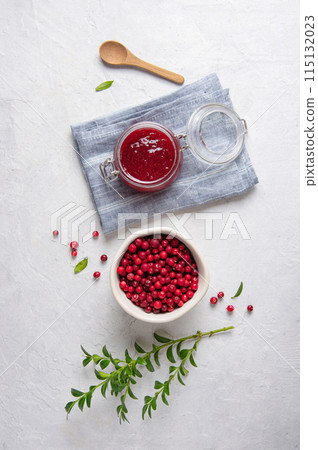 Concept flat lay with homemade lingonberry jam and forest cowberry in bowl on white table Concept flat lay with homemade lingonberry jam and forest cowberry in bowl on white table 115132023