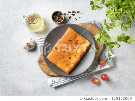 Raw salmon, greased with marinade with spices on a plate on a light background  115132069