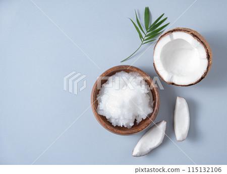 Fresh coconut oil and coconut slices on blue background. Healthy and vegan food. Top view Fresh coconut oil and coconut slices on blue background. Healthy and vegan food. Top view 115132106