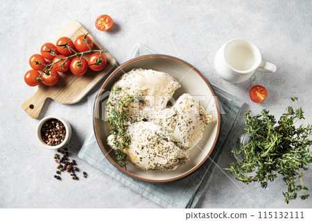 Baked chicken fillet in a creamy sauce with thyme in a bowl on a light background  115132111