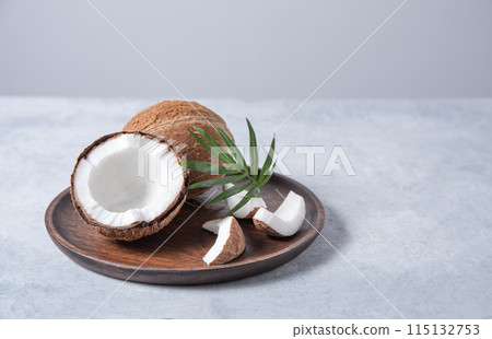 Eco friendly flat lay. Fresh coconut and slices in wooden plate  on blue  background.  115132753