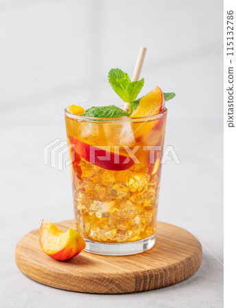 Refreshing peach iced mint tea. The concept of a healthy homemade cold summer drink Refreshing peach iced mint tea. The concept of a healthy homemade cold summer drink 115132786