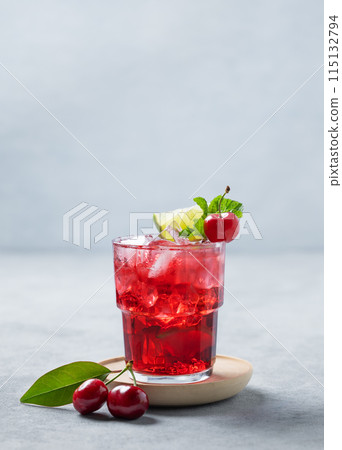 Cherry-lime mojito cocktail with mint, lime and ice on a blue background with fresh berries. 115132794